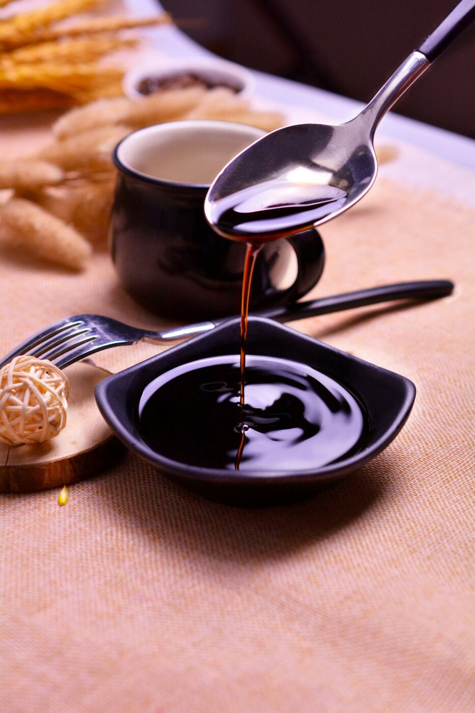 Traditional balsamic vinegar, dark and syrupy, poured from a spoon