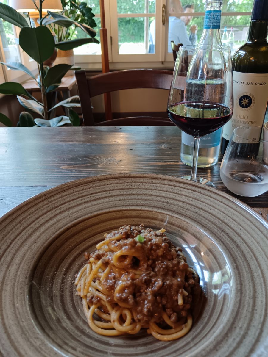 Pasta with ragù and a glass of red, with Tenuta San Guido olive oil