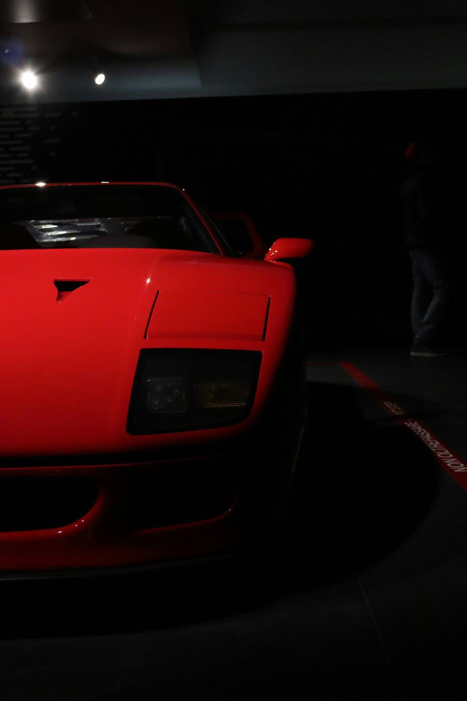 A red Ferrari F40 under the museum lights