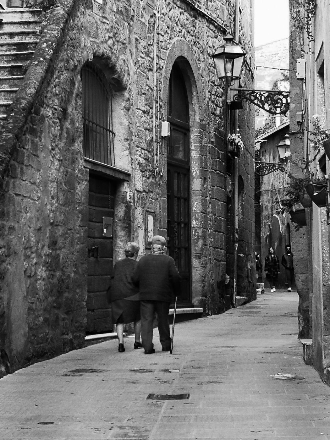 An elderly couple walking a lane in Pitigliano