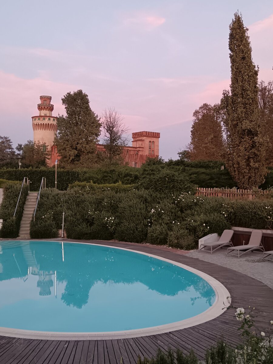 The pool of the Albergo dell'Agenzia with Pollenzo castle at sunset