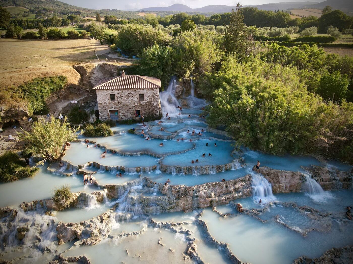 The Cascate del Mulino of Saturnia seen from above, with bathers in the warm pools