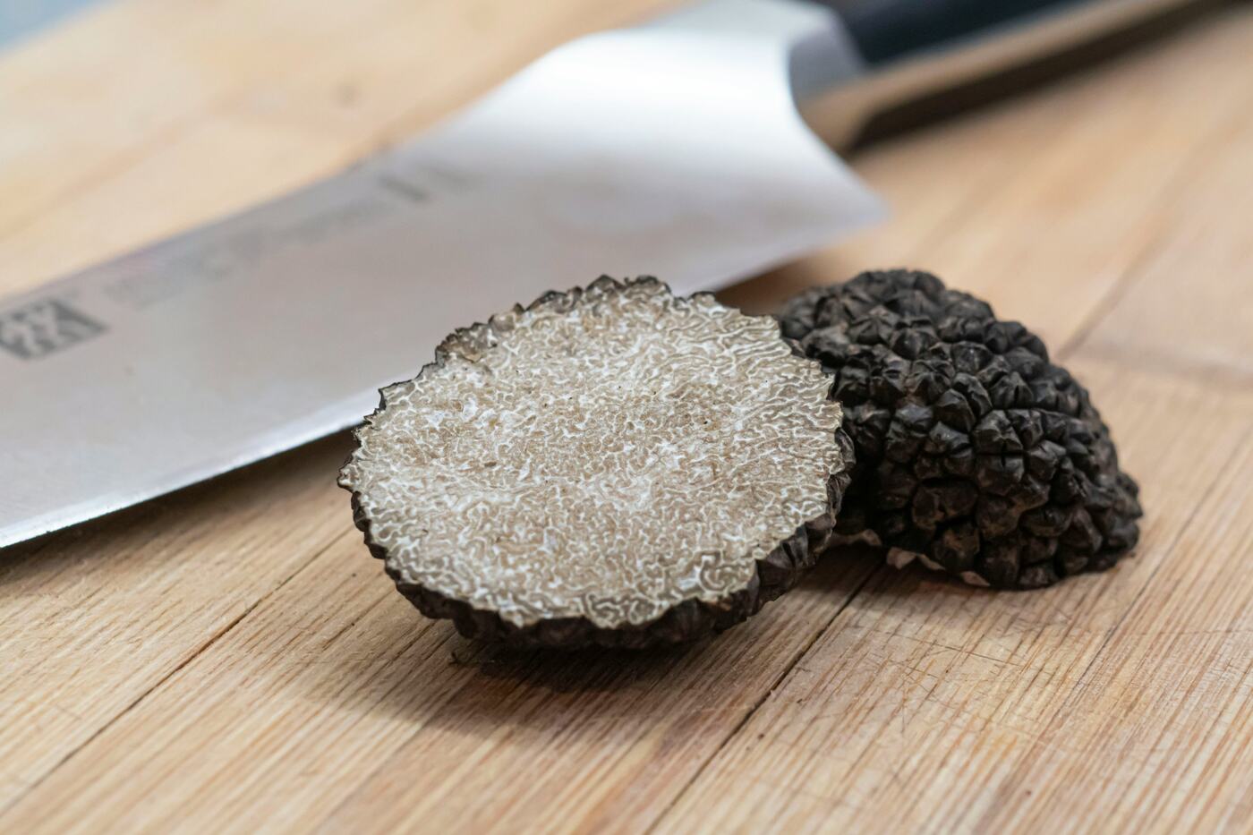 A black truffle cut in half to show the marbled flesh