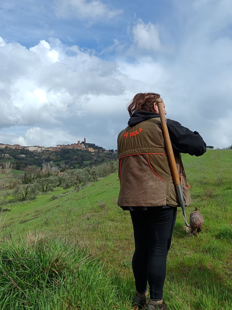 A truffle hunter and her dog on the hills facing San Miniato